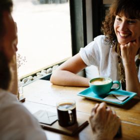 Two people sitting at a table talking about their credit.