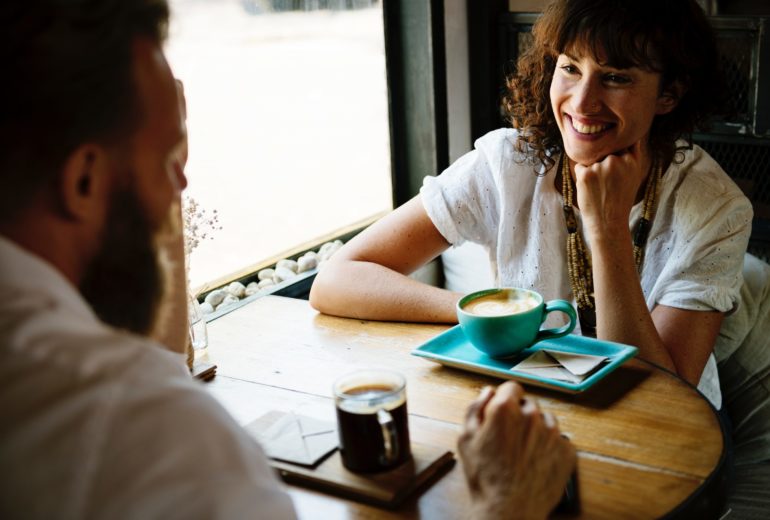 Two people sitting at a table talking about their credit.