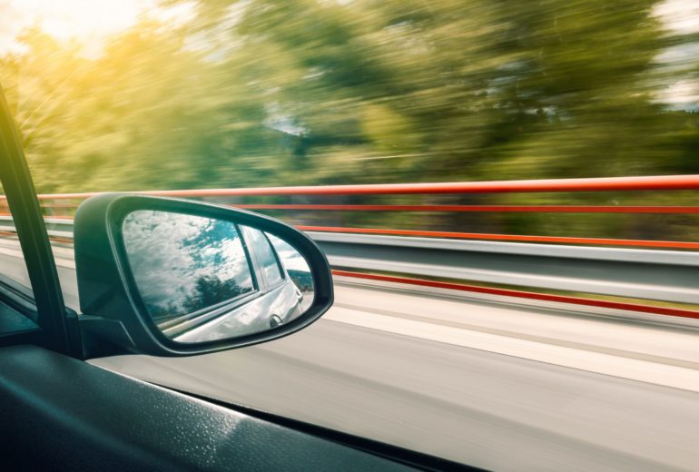 View from a car window driving on a road.