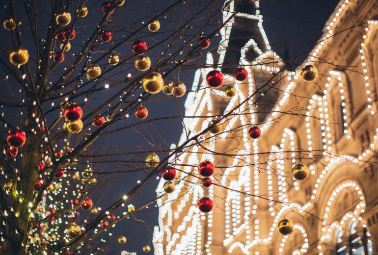 Outdoor Christmas lights and ornaments on a tree.