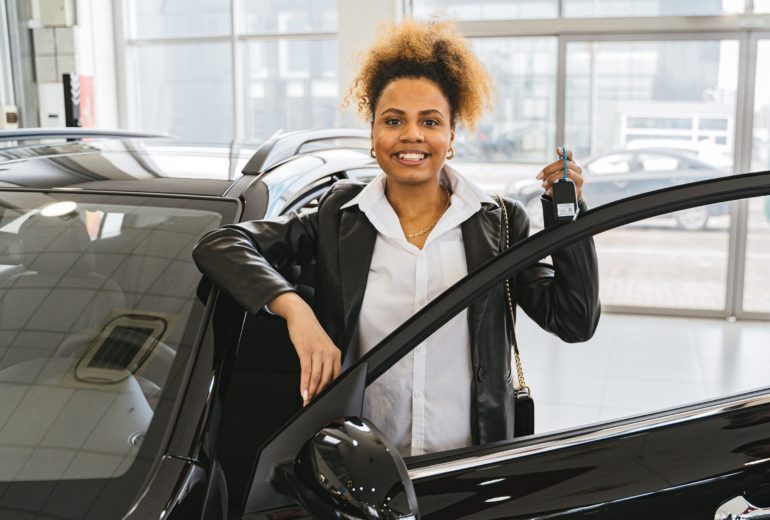 Woman standing with new car.