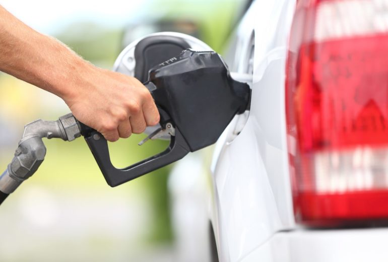 Close-up of someone pumping gas.