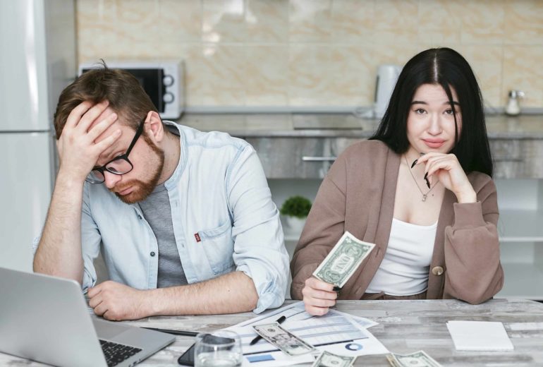 A couple reviewing their credit card debt and counting cash.